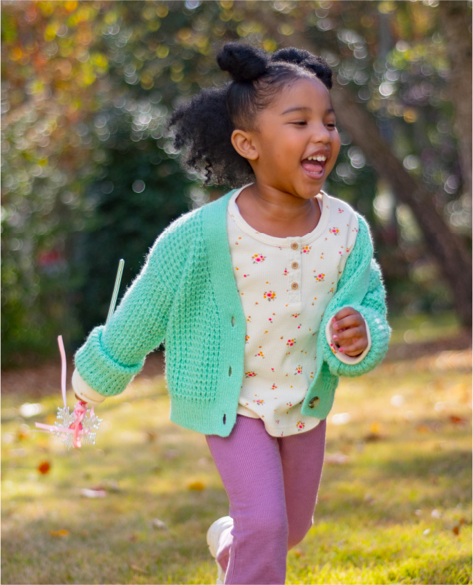 A young girl running and laughing in autumn.